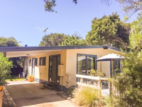 a small yellow house with a lot of windows at Beachwalk Cottage in Sorrento