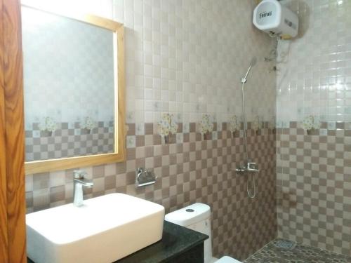 uma casa de banho com um lavatório, um espelho e um WC. em Thanh Truc Hotel Ca Mau em Cà Mau