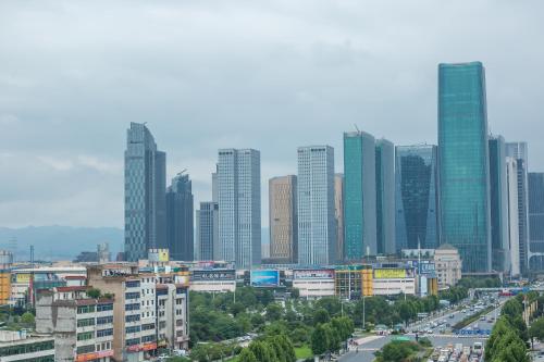 a city skyline with tall buildings and a freeway at Byland Star Hotel in Yiwu