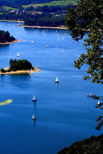 a group of boats in a large body of water at Apartamenty Pokoje w Bieszczadach Solina polańczyk in Polańczyk