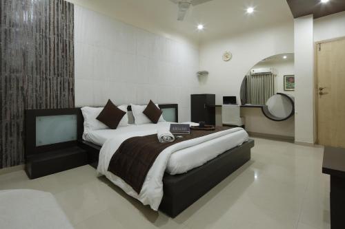 a bedroom with a large bed in a room at Hotel Volga in Ahmedabad