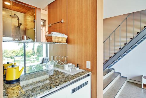 a kitchen with a counter with a sink and a staircase at Jeju Bom stay & Art Gallery in Seogwipo