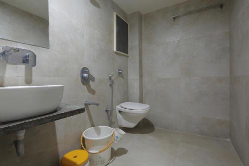 a bathroom with a toilet and a sink at Hotel Volga in Ahmedabad