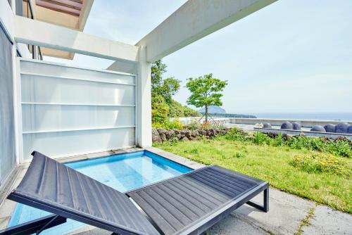 a small swimming pool on the side of a house at Jeju Bom stay & Art Gallery in Seogwipo