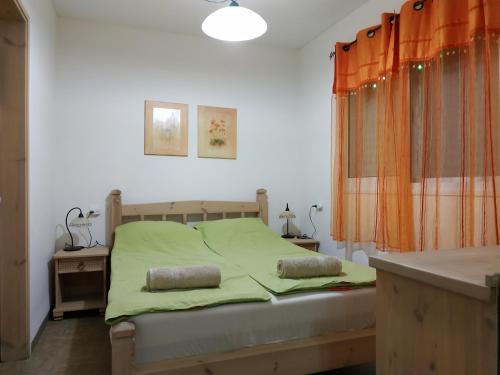 een slaapkamer met een bed met groene lakens en een raam bij Bait Katan Be Yonatan in Yonatan