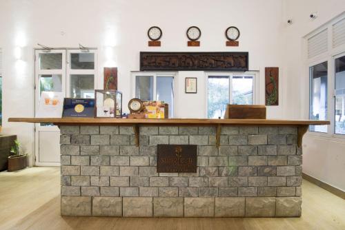 a brick counter in a room with clocks on the wall at Sungreen Resort Habarana in Habarana