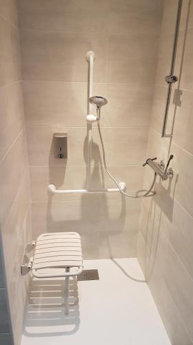 a white bathroom with a sink and a stool at Logis Hotel Yseria - Historical Center in Agde