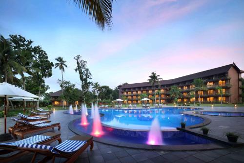 a swimming pool with fountains in front of a hotel at Uday Backwater Resort in Alleppey