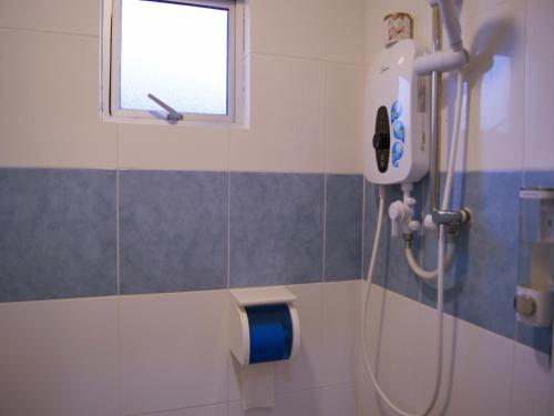 a shower in a bathroom with a window at Santorini Hotel Melaka in Melaka