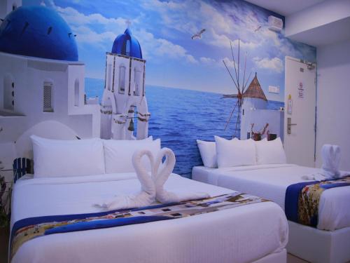 a room with two beds with a view of the ocean at Santorini Hotel Melaka in Melaka