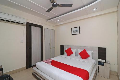 a bedroom with a large bed with red pillows at Hotel Mandiram in Allahābād