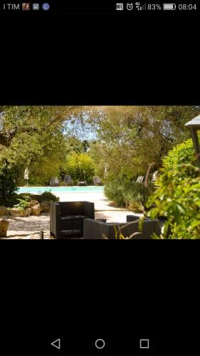 a picture of a patio with chairs and trees at Agriturismo Grotta Di Figazzano in Cisternino