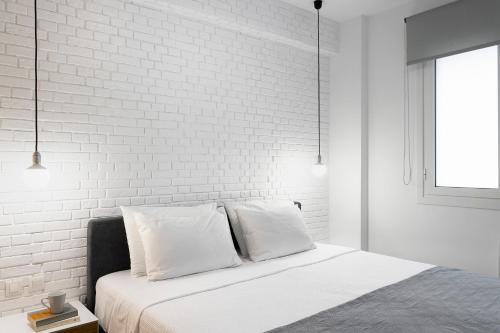 a bedroom with a white brick wall and a bed at Athens View Loft 07 & 08 in Athens