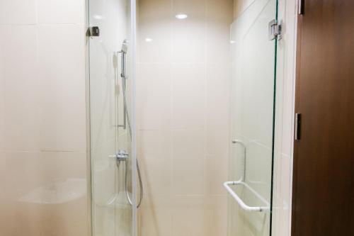 a bathroom with a shower with a glass door at 1BR Apartment at M-Town Residence near Summarecon Mall Serpong By Travelio in Tangerang