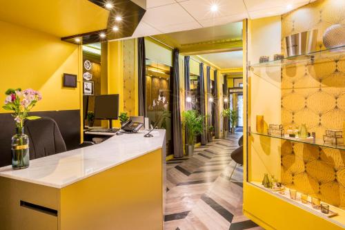 an office with yellow walls and a reception desk at Best Western Hotel Centre Reims in Reims