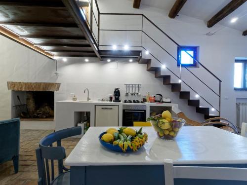 a kitchen with a table with a bowl of fruit on it at L’Arrocco - La Torre col Mare sul Tetto in Tarquinia