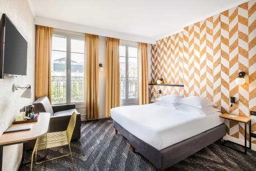 ein Hotelzimmer mit einem großen Bett und einem Schreibtisch in der Unterkunft Best Western Hotel Centre Reims in Reims