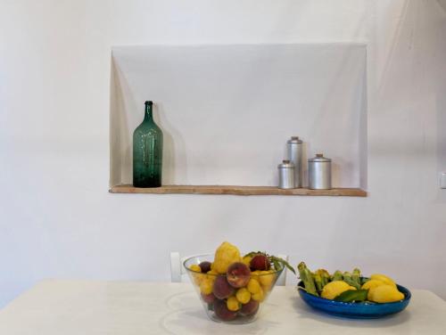 a bowl of fruit and a bottle on a counter at L’Arrocco - La Torre col Mare sul Tetto in Tarquinia