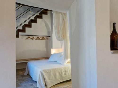 a white bedroom with a bed and a staircase at L’Arrocco - La Torre col Mare sul Tetto in Tarquinia