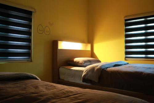 a bedroom with two beds and a mirror at Daegwanryeong Egg Guesthouse in Pyeongchang 