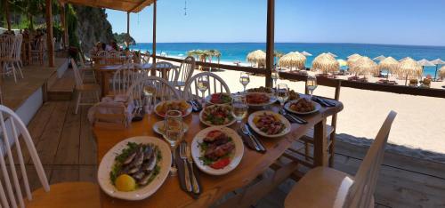 a table with plates of food on the beach at Aegean House in Agios Dimitrios