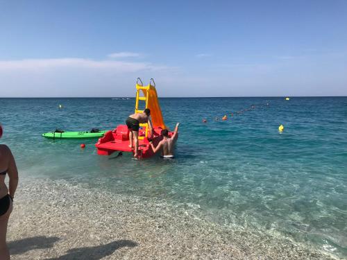 a man on the beach with a sail boat in the water at Aegean House in Agios Dimitrios