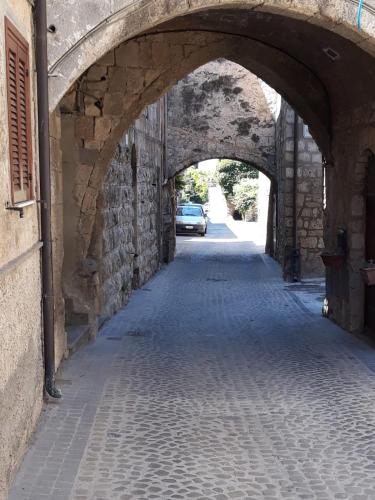 an alley with an archway in a building with a car under it at L’Arrocco - La Torre col Mare sul Tetto in Tarquinia