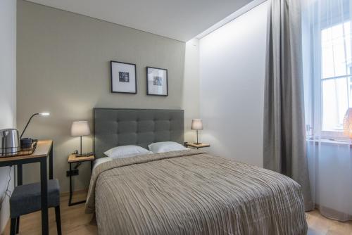 a bedroom with a bed and a desk and a window at Amber Suites - Stikliu 20 in Vilnius