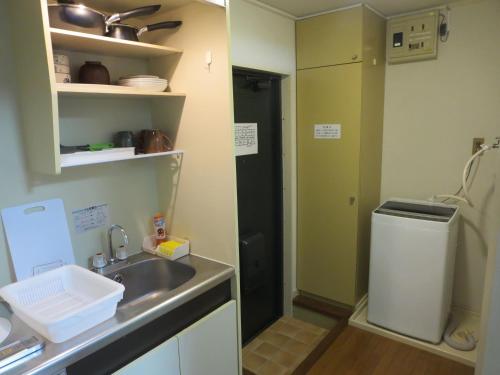 熊本市にあるComfort CUBE PHOENIX S Kumamotoのシンクと冷蔵庫のある小さなキッチン
