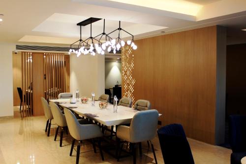 a dining room with a long table and chairs at Novotel Ahmedabad in Ahmedabad