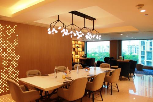 a dining room with a long table and chairs at Novotel Ahmedabad in Ahmedabad