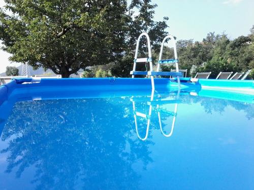 a swimming pool with two chairs in the water at Agriturismo PeterPan in Pietra Ligure