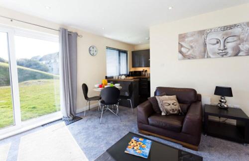 a living room with a couch and a table at Valley Lodge in Trearddur