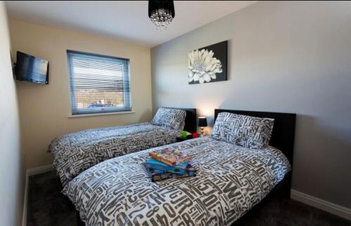a bedroom with a bed and a bed and a window at Valley Lodge in Trearddur