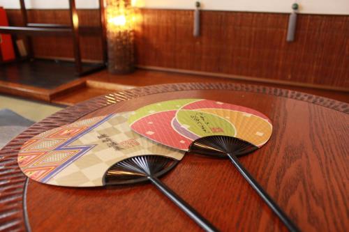 a wooden table with two spoons on top of it at Koyado Enn in Toyooka