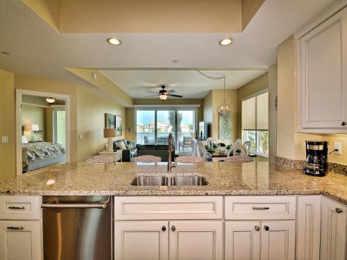 a kitchen with a sink and a living room at Sandpiper's Cove 203 Luxury Waterfront 3 Bedroom 2 Bath Condo 23130 in Clearwater Beach