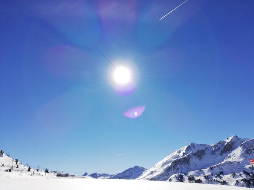 a sun in the sky over a snow covered mountain at Brandstättergut in Mariapfarr