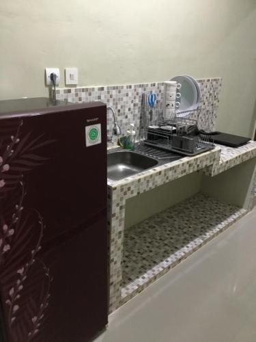 a small kitchen with a sink and a stove at The Villa's Kubu Sandan in Kintamani