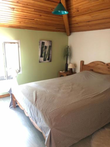 une chambre avec un grand lit avec un plafond en bois dans l'établissement Villa Soustons Plage à 1,7km,Golf à 900m,Jacuzzi ,wifi,Bbq, à Soustons