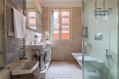 ein Bad mit einem Waschbecken, einem WC und einer Dusche in der Unterkunft Carmini Canal View and balcony with Lift in Venedig