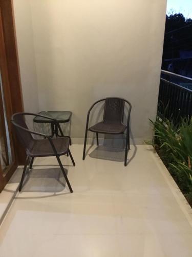 two chairs on a balcony with a window at The Villa's Kubu Sandan in Kintamani