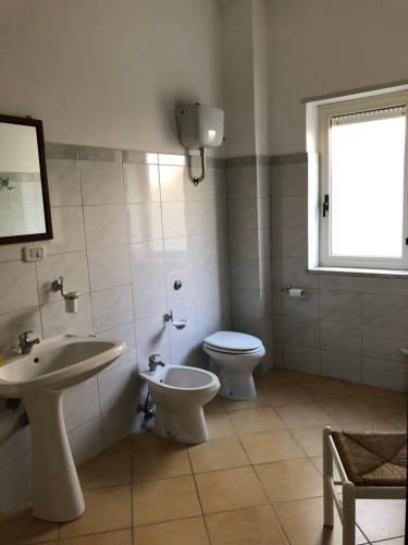 a bathroom with a sink and a toilet and a window at Bed & Breakfast "Camera a Sud" in Cariati