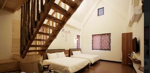 two beds in a room with a staircase at 午后咖啡民宿 in Puli