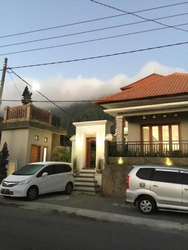 two cars parked in front of a house at The Villa's Kubu Sandan in Kintamani