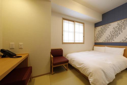 a bedroom with a bed and a desk and a telephone at Onyado Nono Asakusa Natural Hot Spring in Tokyo