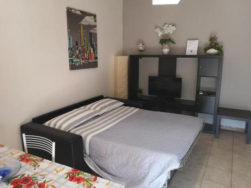 een slaapkamer met een bed, een bureau en een televisie bij Casa Vacanza Pse in Porto SantʼElpidio
