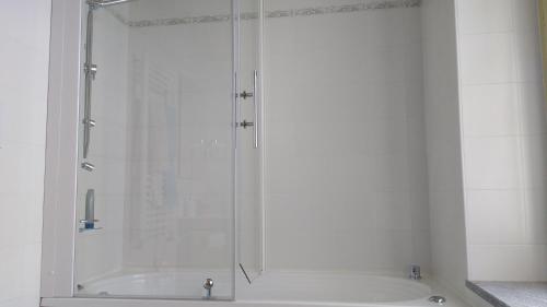 a shower in a white bathroom with a tub at Agriturismo Cascina Poscallone in Abbiategrasso