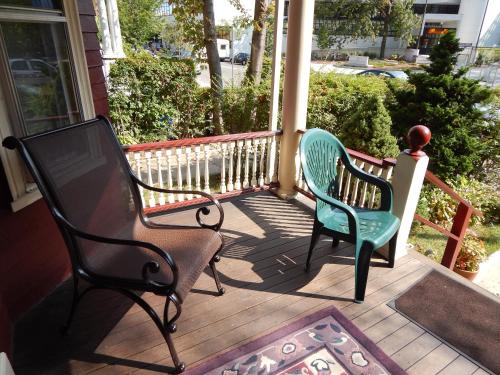 two chairs sitting on the front porch of a house at A Friendly Inn at Harvard in Cambridge
