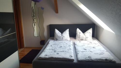 a bedroom with a bed with two pillows at Ferienwohnung am Sternhagener See in Lindenhagen