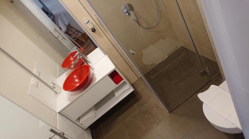 a bathroom with a red sink and a shower at Maison am Liesingbach in Vienna